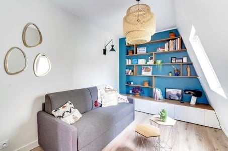 An attic living space with library shelves under the eaves